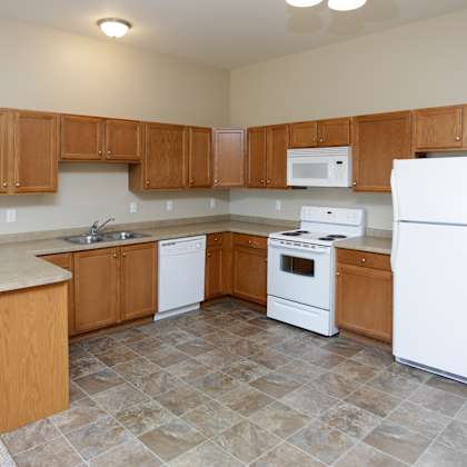 a kitchen with white appliances and wooden cabinets.