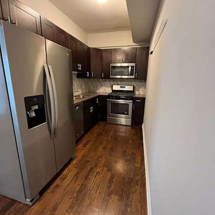a kitchen with stainless steel appliances and wooden floors