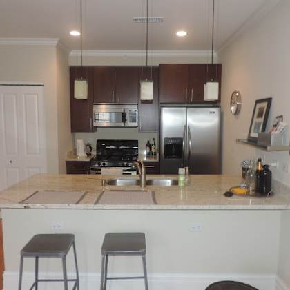 a kitchen with a bar and a stainless steel refrigerator