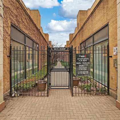 a gate with a sign on it in front of a building