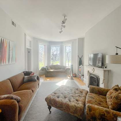 a living room with a brown couch and a fireplace.