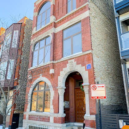 a brick building with a wooden door and a no parking sign