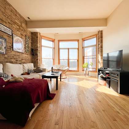 a living room with a red bedspread and a white couch.