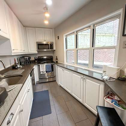 a kitchen with white cabinets and a black stove top.
