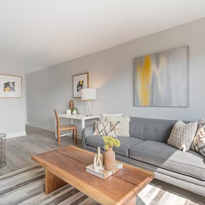 a living room with a gray couch and a wooden coffee table