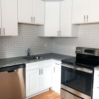 a kitchen with white cabinets and a black oven.