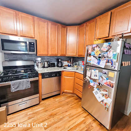 a kitchen with wooden cabinets and a fridge covered in photos.
