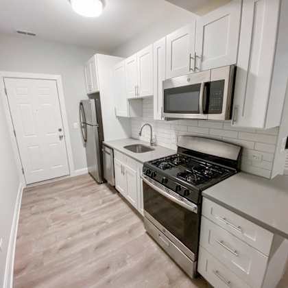 a kitchen with white cabinets and appliances.