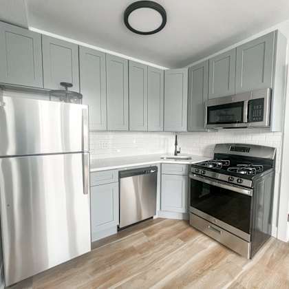 a modern kitchen with a stainless steel refrigerator, oven, and microwave.