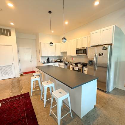 a kitchen with a bar area and white cabinets.