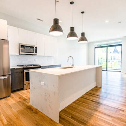 a kitchen with white cabinets and stainless steel appliances and a large island
