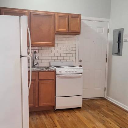 a kitchen with a white refrigerator and wooden cabinets.