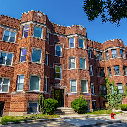 a red brick building with a black gate in front.