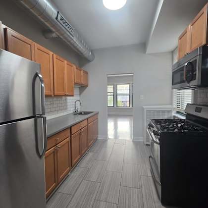 a kitchen with a stainless steel refrigerator and black stove top oven.