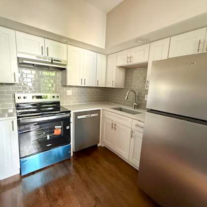 a kitchen with a stove, sink, and refrigerator.