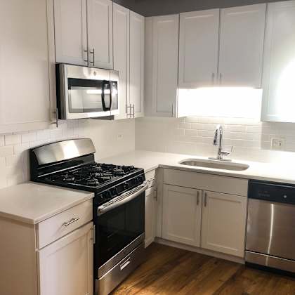a kitchen with white cabinets and a black stove top oven.