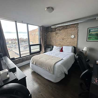 a bedroom with a large bed and a view of the city.