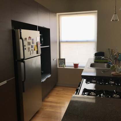 a kitchen with a black fridge and stove top oven.