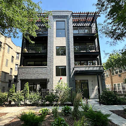a modern building with a black and white facade is surrounded by greenery.