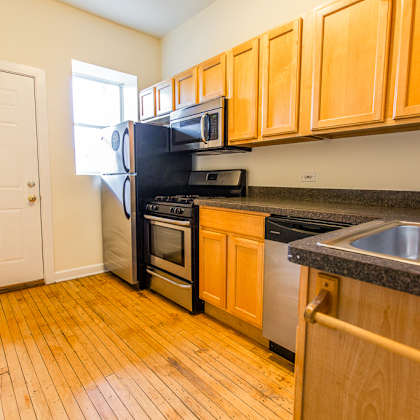 a kitchen with wood flooring and wooden cabinets