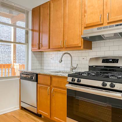 a kitchen with wooden cabinets and a stove top oven.