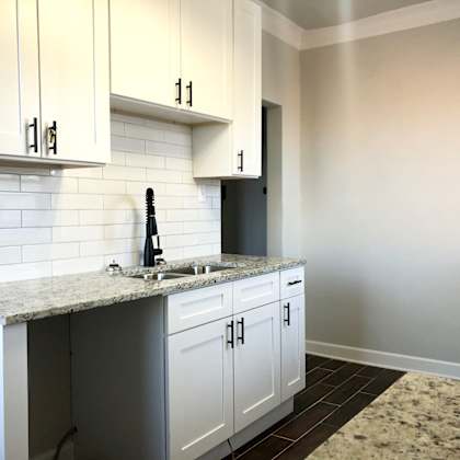 a kitchen with granite countertops and white cabinets.