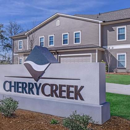 a sign for cherry creek in front of a house