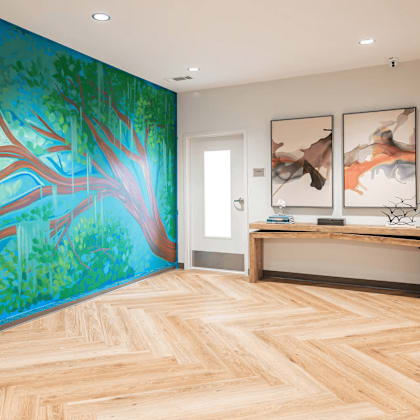 a room with a wooden floor and a mural of a tree on the wall.