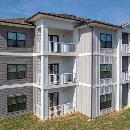 a large two-story apartment building with balconies and multiple windows.