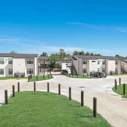 a row of houses with a grassy area in front.