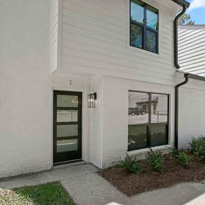 a white house with a black door and windows.