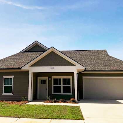 a house with a garage door and a lawn