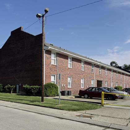 a red brick building with a parking lot in front.