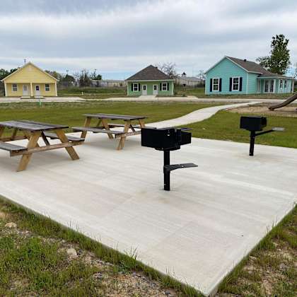 a large patio with picnic tables and a grill on it