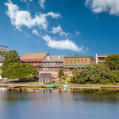 a large building sits on the shore of a lake.