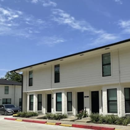 a white building with a black car parked in front.