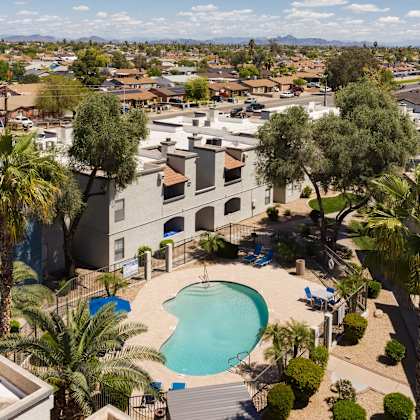 an aerial view of a community with a pool and palm trees