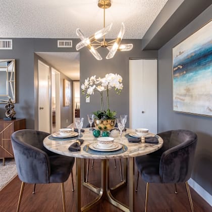 a dining room with a round table set for four.