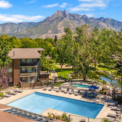 an aerial view of a swimming pool with mountains in the background