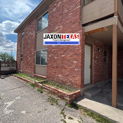 a brick building with a sign that says "jaxonixas" on it.