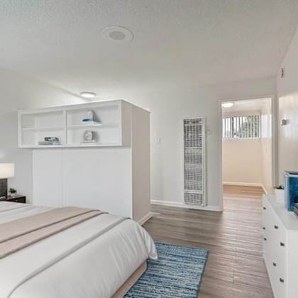 a bedroom with a large bed and a tv on the wall.