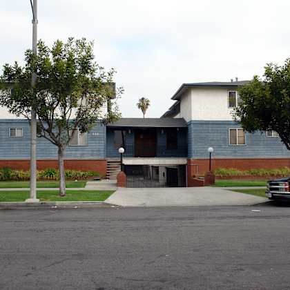 a black truck is parked on the street in front of a blue building.