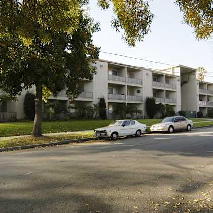 apartment building with cars parked in front.