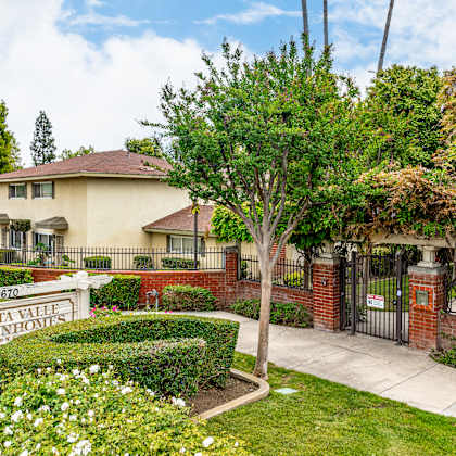 a sign that says vista valley townhouses in front of a house.