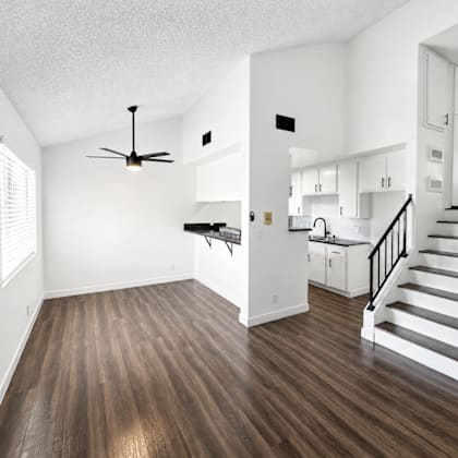 a room with a ceiling fan and wooden floors.