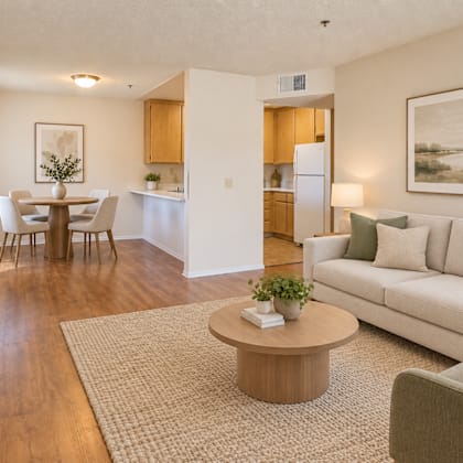 a living room with a couch, a dining table, and a painting on the wall.