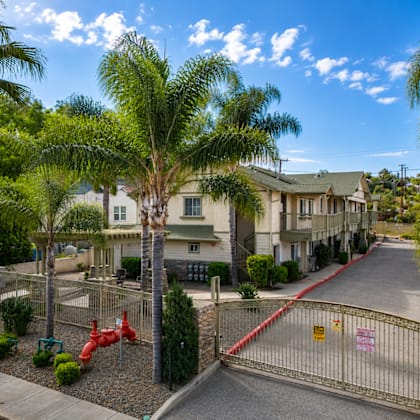 a gated entrance to a residential area with a red fire hydrant.