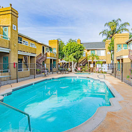 a swimming pool surrounded by a fence and buildings.