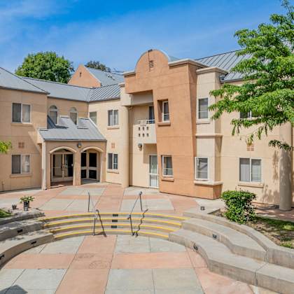 a large building with a circular staircase in front of it at international village ucr student housing, california