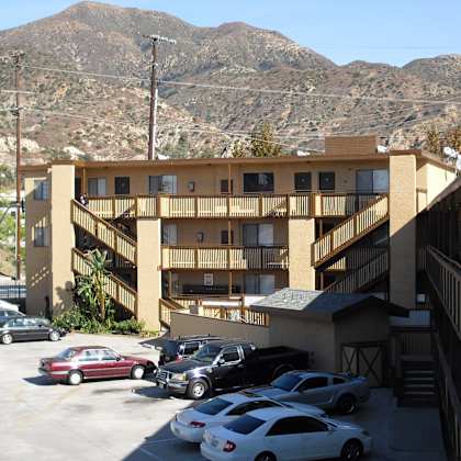a parking lot with cars and a mountain in the background.